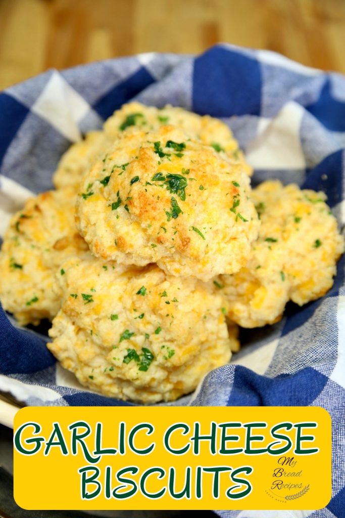 Garlic Cheese Biscuits in a basket with blue towel- text overlay.