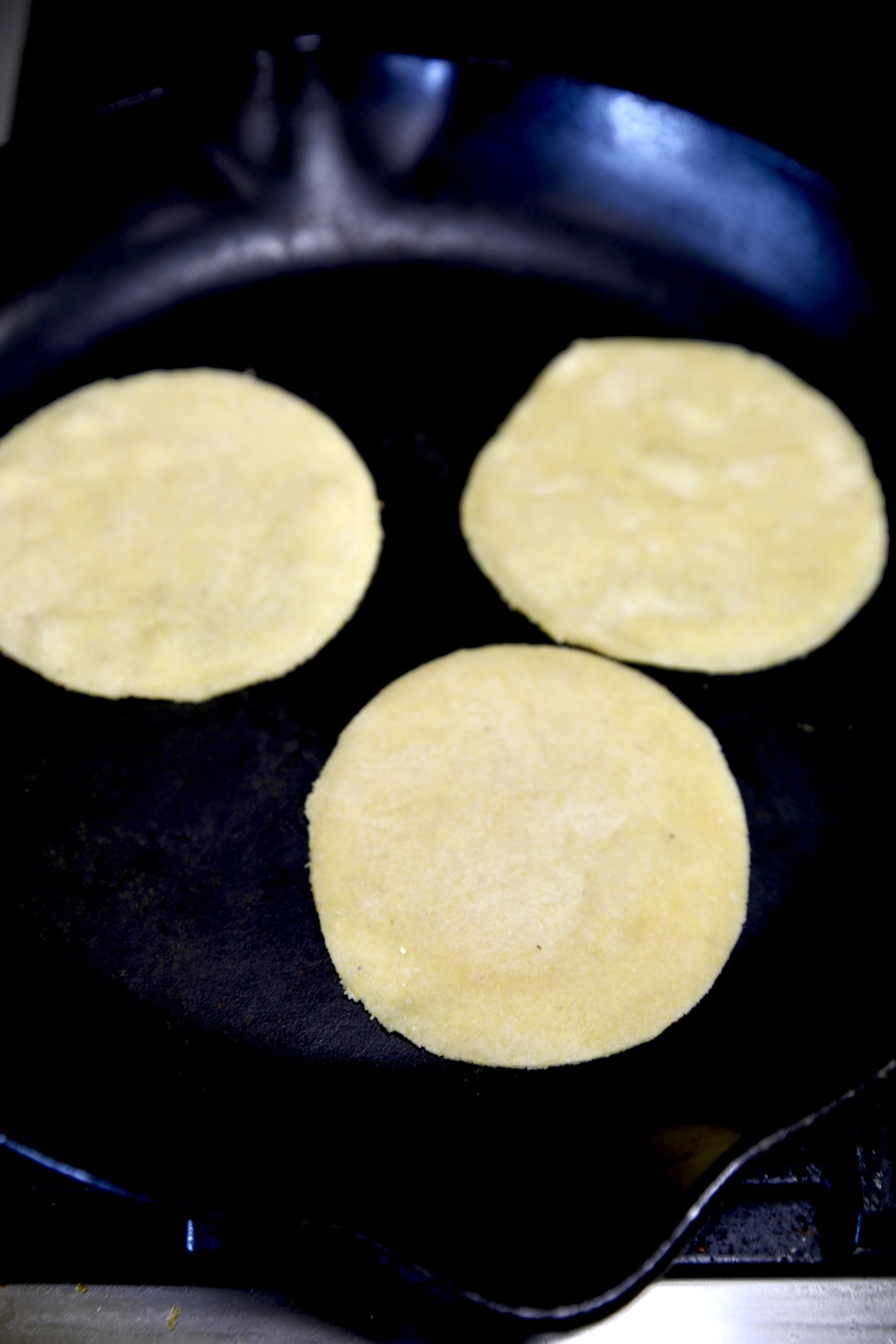 Cooking 3 tortillas in a skillet.