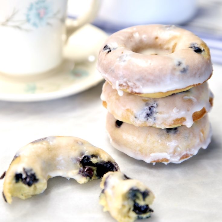 Blueberry donuts stacked and one in pieces.