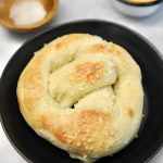 Soft pretzel in a black bowl.