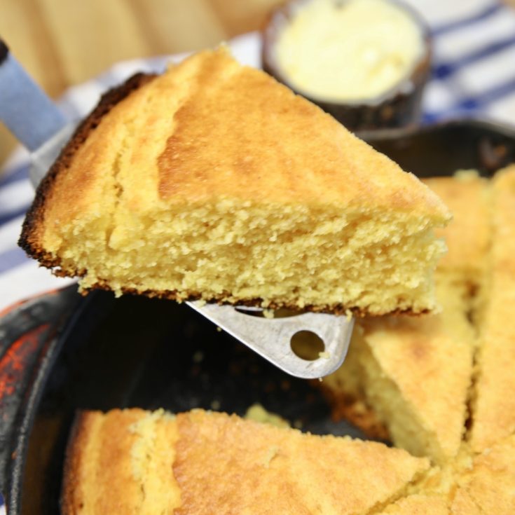 Serving a wedge of cornbread on a spatula.