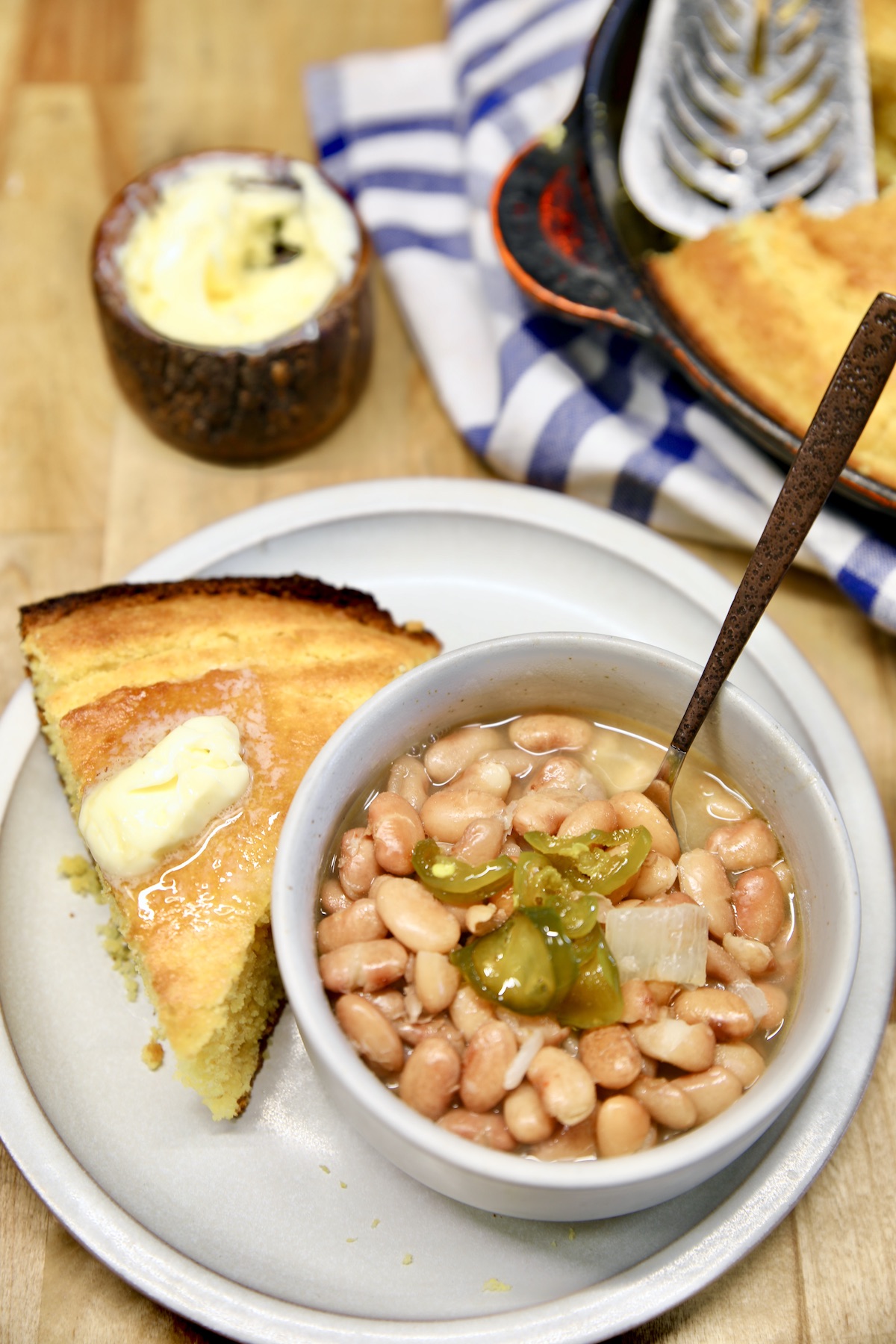 Bowl of pinto beans with slice of cornbread.
