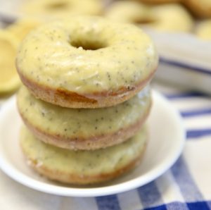 Lemon Poppy Seed Donuts stacked on a plate.