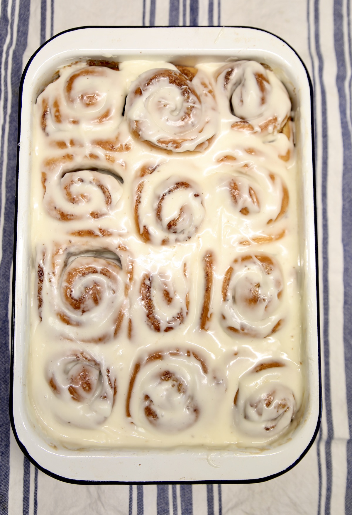 Pan of cinnamon rolls with cream cheese icing.