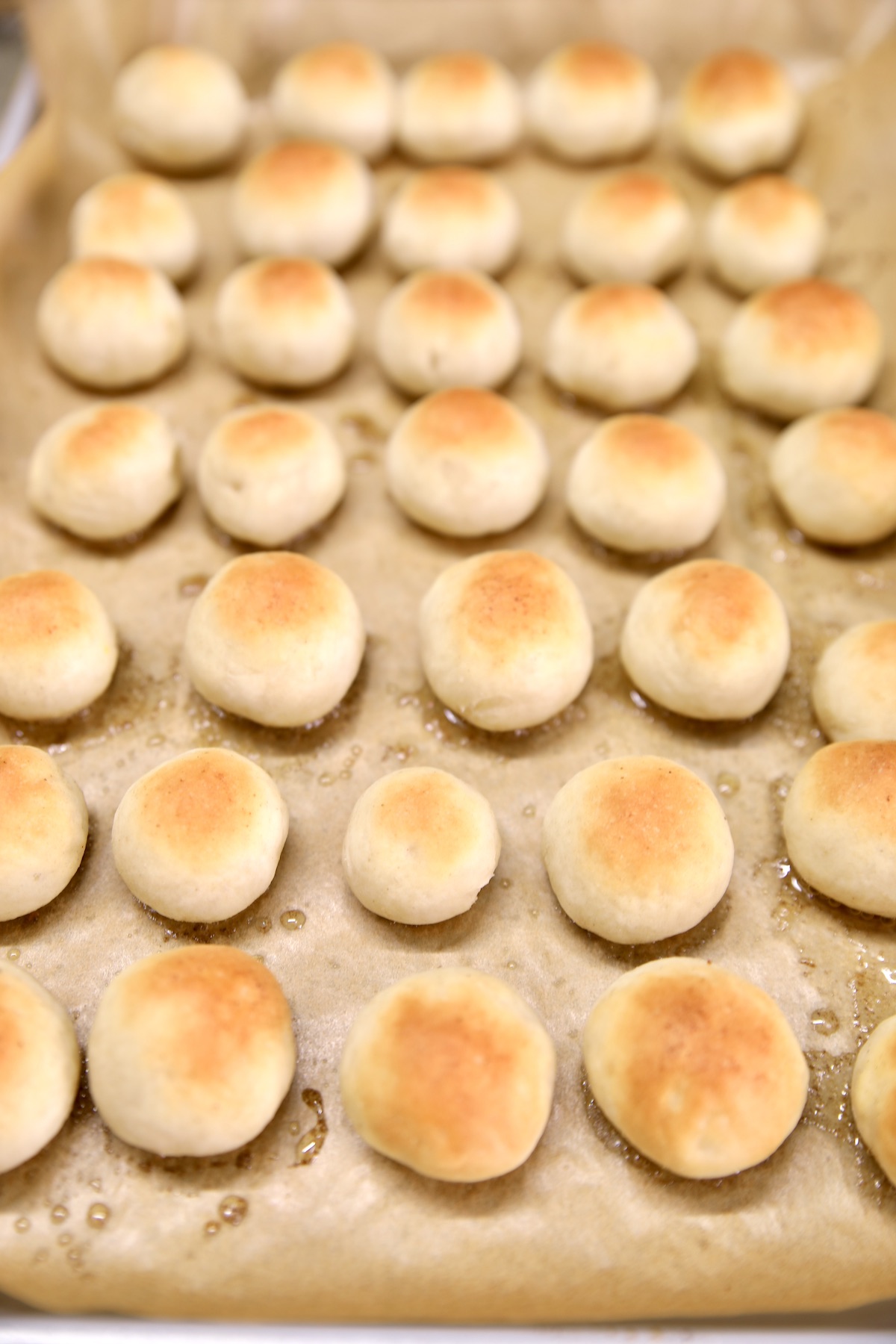 Sheet pan with mini bread rolls.