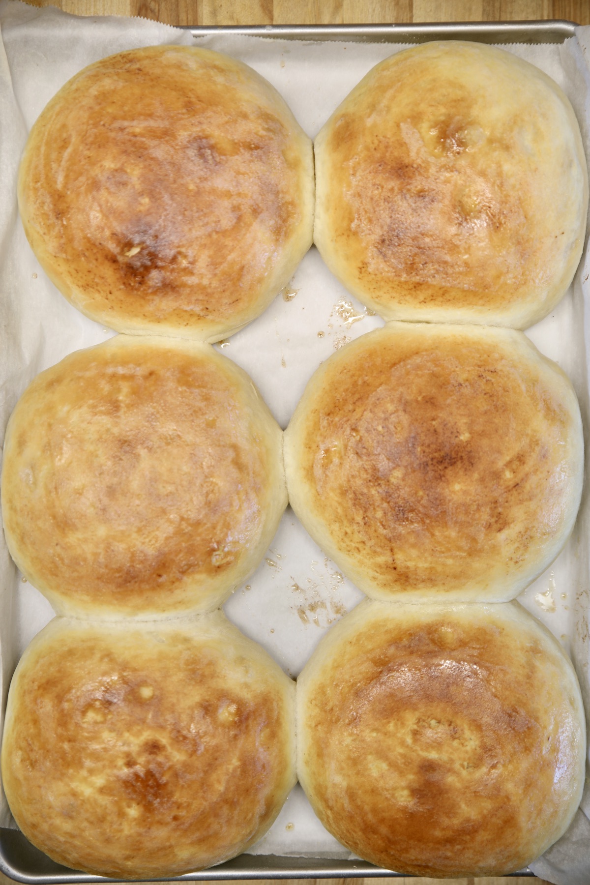 6 baked bread bowls on a baking sheet.