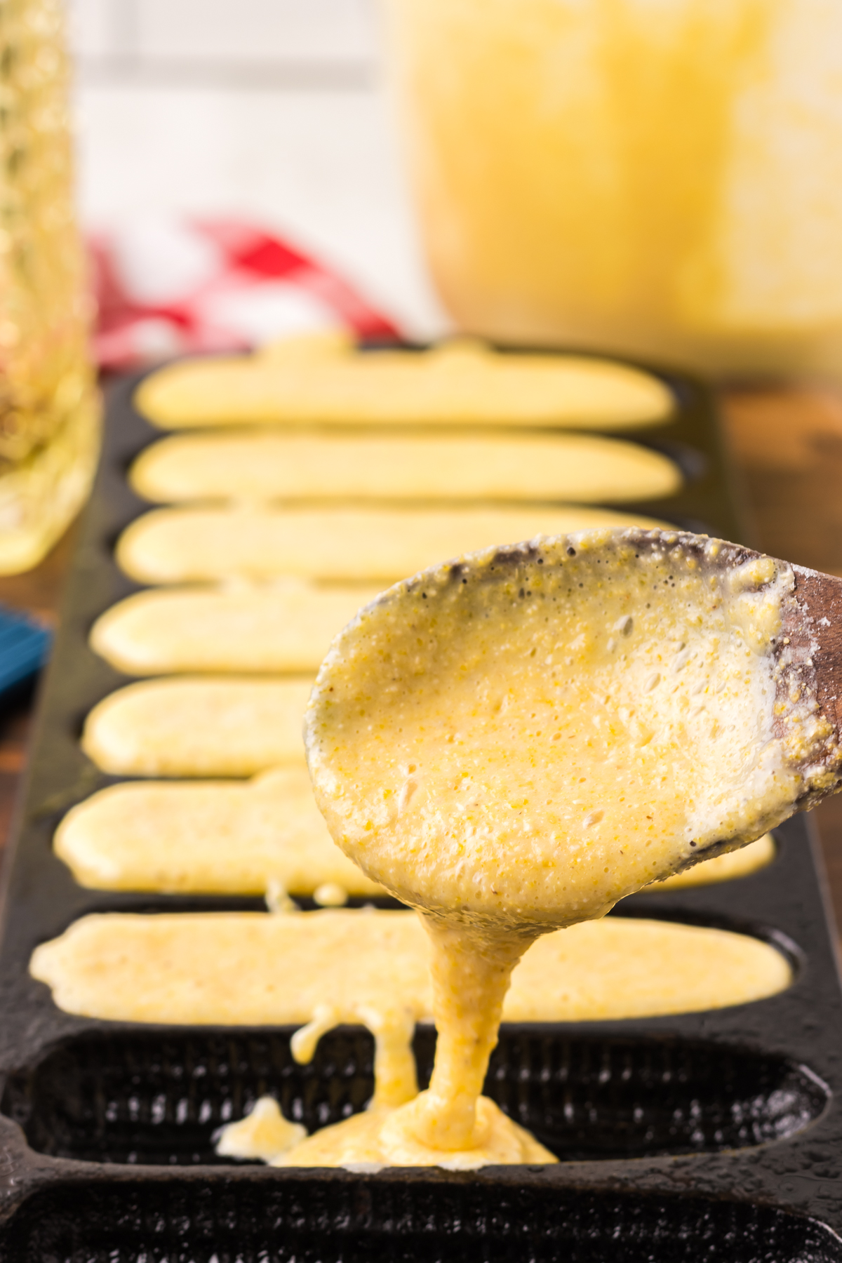 Spooning cornbread batter into skillet.