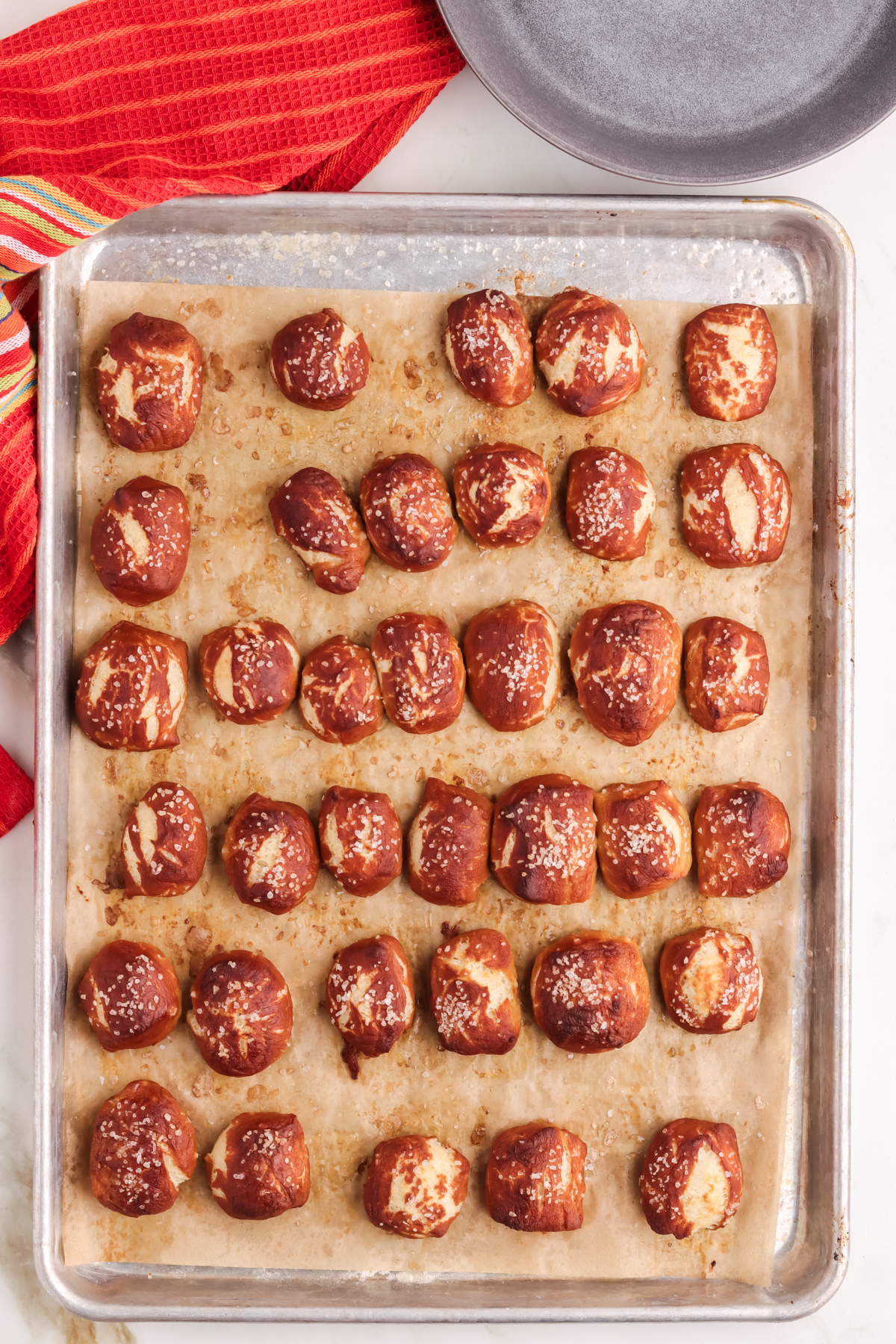 Baked pretzel bites. Baked salted pretzel bites on a lined baking sheet.