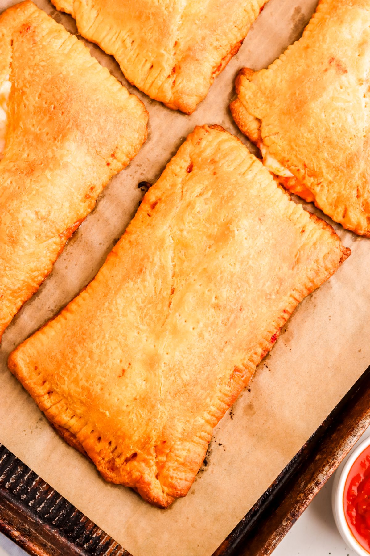 Baked pizza pockets on a lined baking sheets. Baked pizza pockets on a lined baking sheets.
