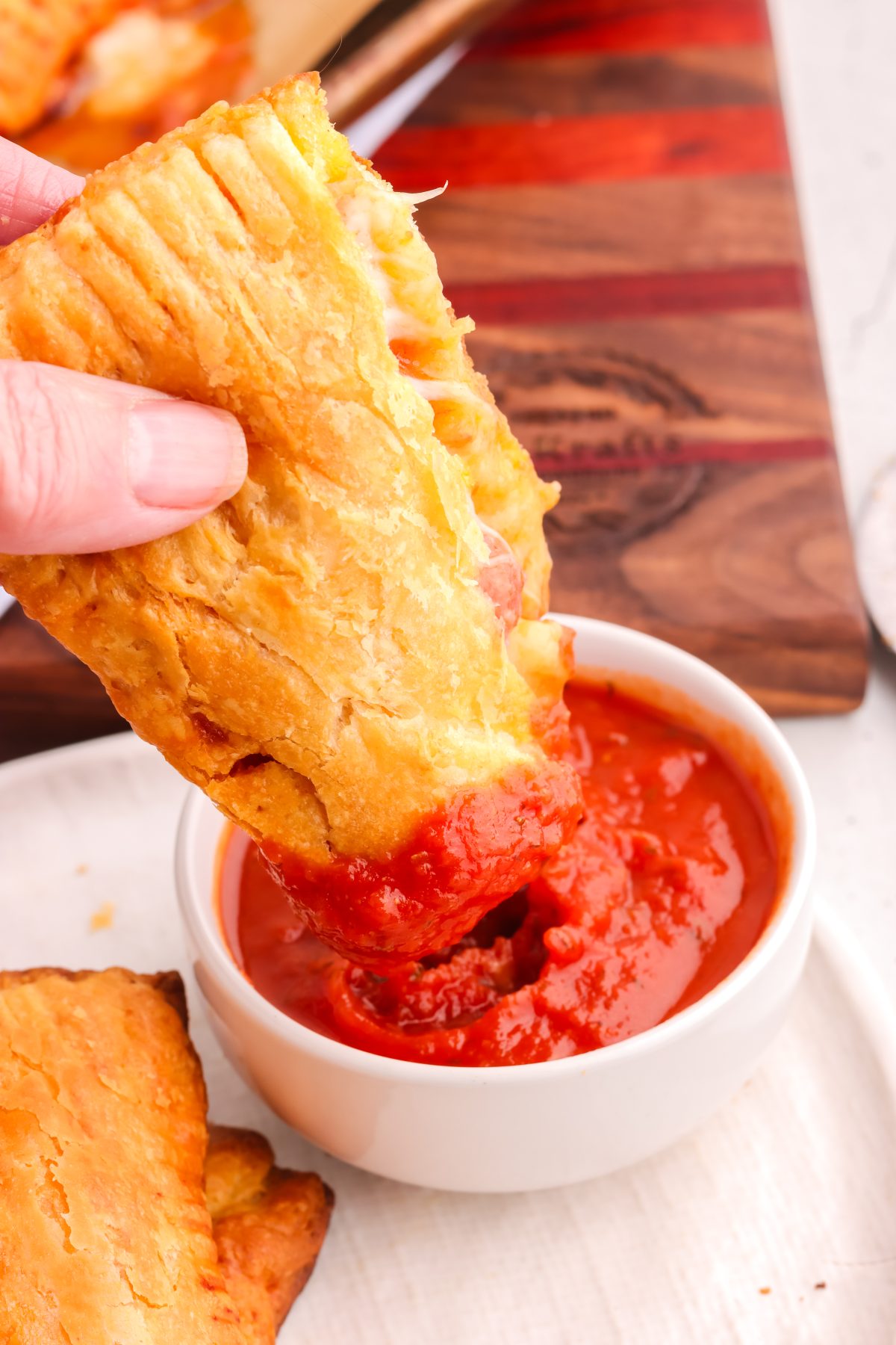 Pizza pocket dipped in marinara sauce. Pizza pocket dipped into marinara sauce.